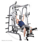 Man using white and gray Smith machine with adjustable bench for barbell exercises on white background