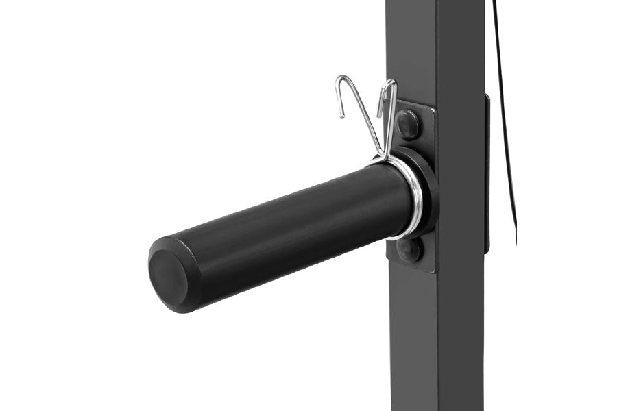 Black cylindrical leg attachment bar with silver metal collar and safety pins mounted on gray Smith machine frame, displayed 