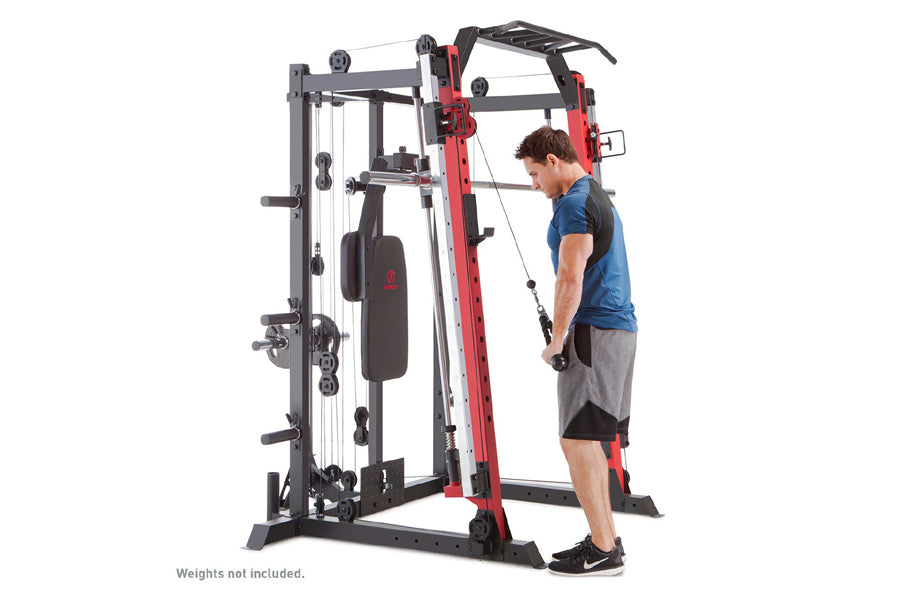Man in blue shirt using red and black Smith machine with cable attachment on white background
