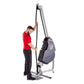 Man in red shirt using gray and black rope training machine with pulley system on white background