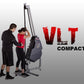 Two people using gray and black VLT Compact rope training machine with red "VLT COMPACT" logo on white background
