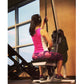 Woman wearing hot pink sleeveless top and burgundy patterned capris using Marpo VLT Compact Rope Trainer in gym setting with 