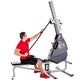 Man in red shirt using gray and black Marpo VMX 360 rope trainer machine with adjustable arm on white background