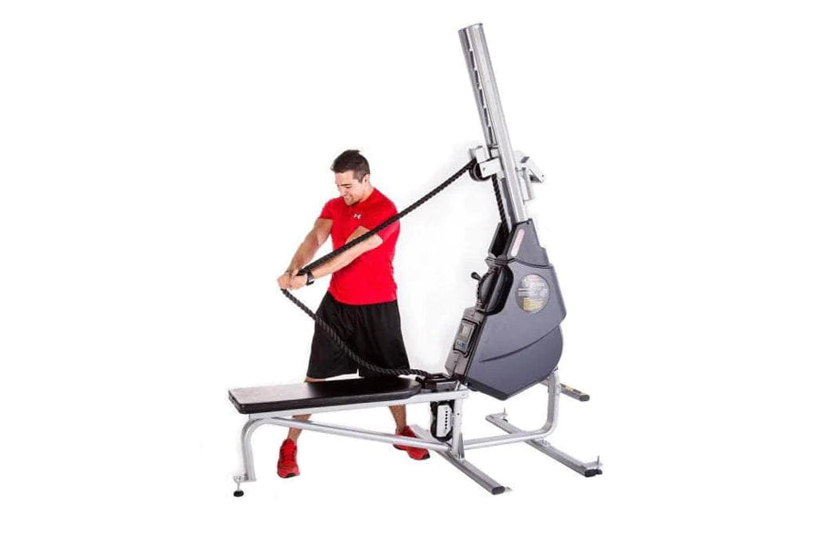 Male athlete in red shirt using gray and blue Marpo VMX 360 rope trainer with adjustable arm on white background