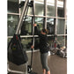 Woman using black Marpo VMX rope trainer with pulley system in gym setting