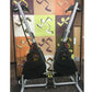 Pair of black Marpo VMX rope trainers with silver frames and yellow accents, displayed on stand against colorful abstract bac