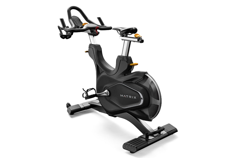 Matrix CXC indoor training bike with black seat and frame, adjustable handlebars, and foot pedals on white background