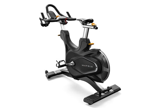 Matrix CXC indoor training bike with black seat and frame, adjustable handlebars, and foot pedals on white background