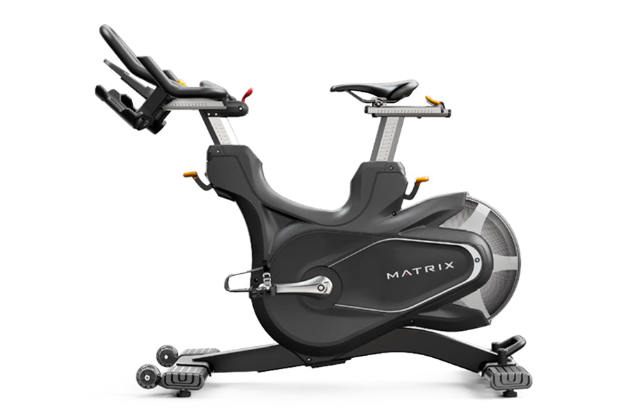 Matrix CXC black indoor cycling bike with gray frame and dual handlebars on white background
