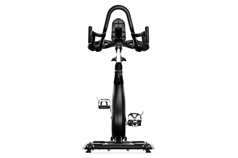 Matrix CXC indoor training bike with black frame, curved handlebars, and platform pedals, viewed from front on white backgrou