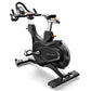 Matrix CXM black indoor training cycle with curved seat, handlebars with digital display, and extended footrest on white back