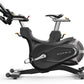 Matrix CXM indoor training cycle with black frame, padded seat, adjustable handlebars, and dual foot pedals on white backgrou