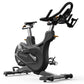 Black Matrix indoor stationary bike with curved handlebars, leather seat, and gold accents on white background