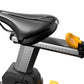 Black padded stationary bike seat with yellow resistance adjustment knob on gray metal post, on white background