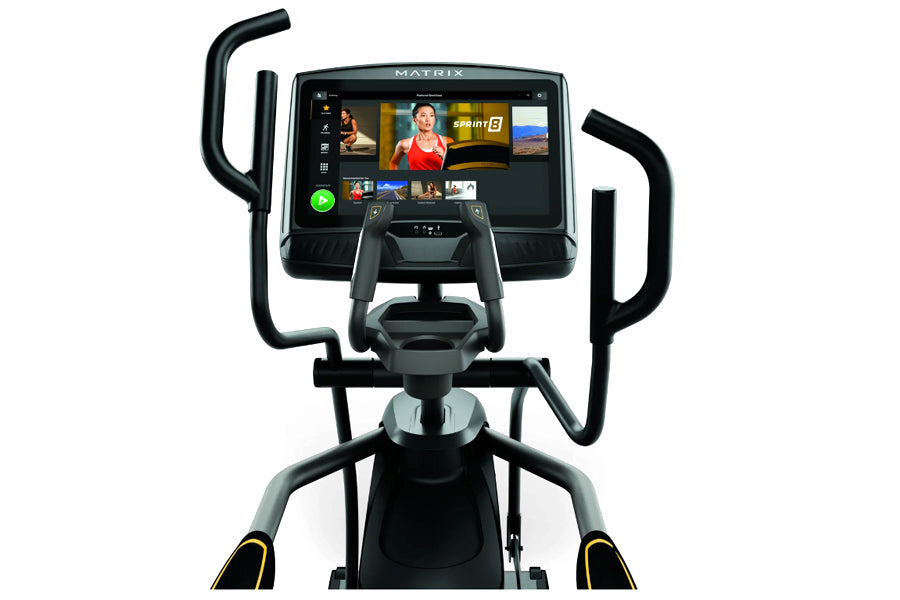 Matrix E50 elliptical machine with black frame, curved handles, and touchscreen display showing fitness content