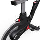 Matrix IC7 Indoor Club Group Cycle close-up of flywheel, red resistance knob, adjustable seat post, and SPD pedals