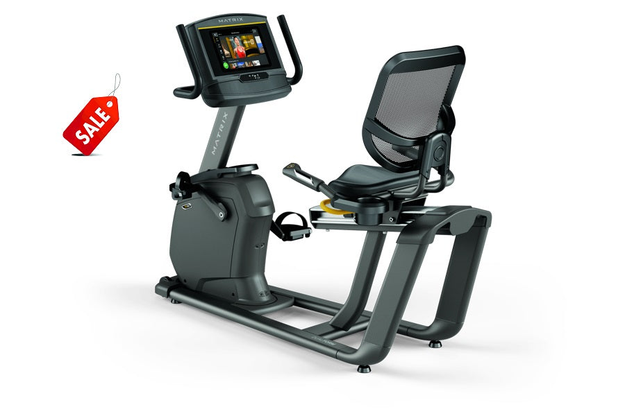Matrix R30 recumbent exercise bike with black mesh seat back, gray frame, digital display console, and red sale tag on white 