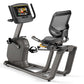 Matrix R30 recumbent exercise bike with gray frame, black mesh seat back, digital display console, and foot pedals on white b
