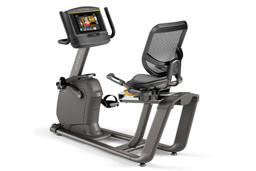Matrix R30 recumbent exercise bike with gray frame, black mesh seat back, digital display console, and foot pedals on white b