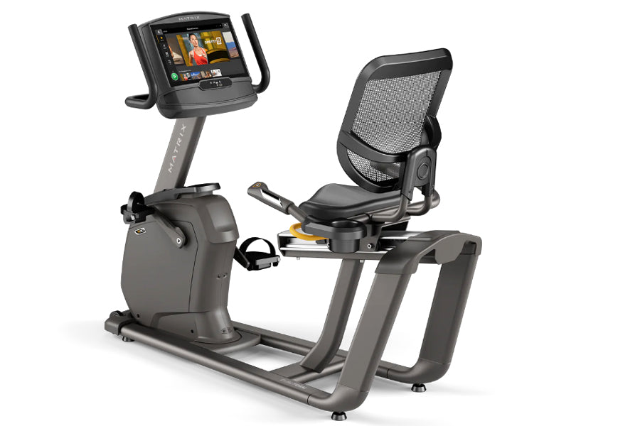 Matrix R30 recumbent exercise bike with black mesh seat back, gray frame, digital display console, and foot pedals on white b
