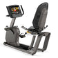 Matrix R50 recumbent exercise bike with gray frame, black mesh backrest, touchscreen display showing workout content, and foo
