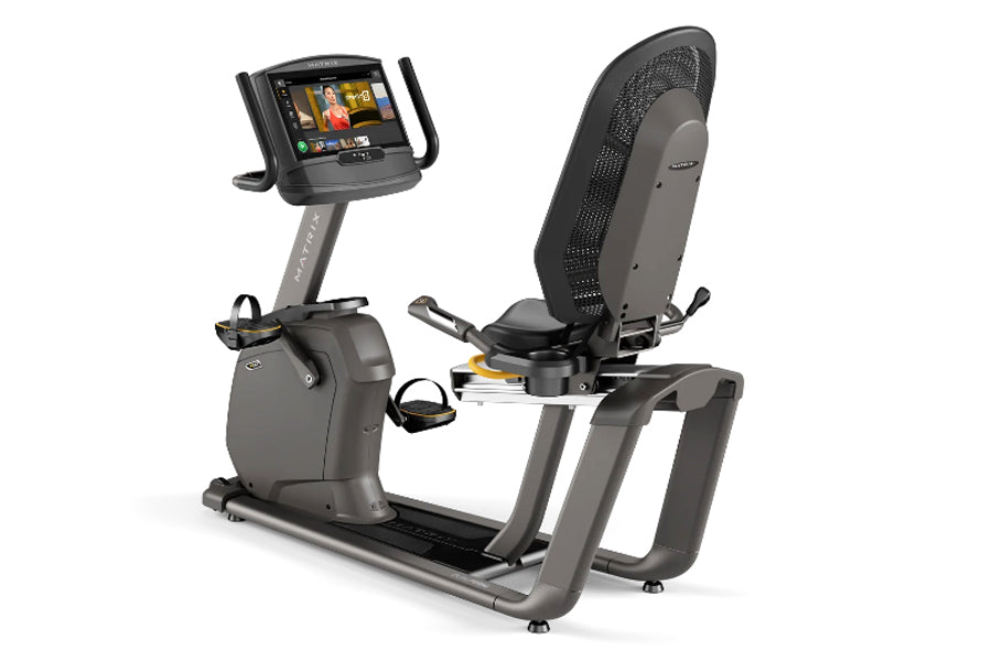 Matrix R50 recumbent exercise bike with gray frame, black mesh backrest, touchscreen display showing workout content, and foo