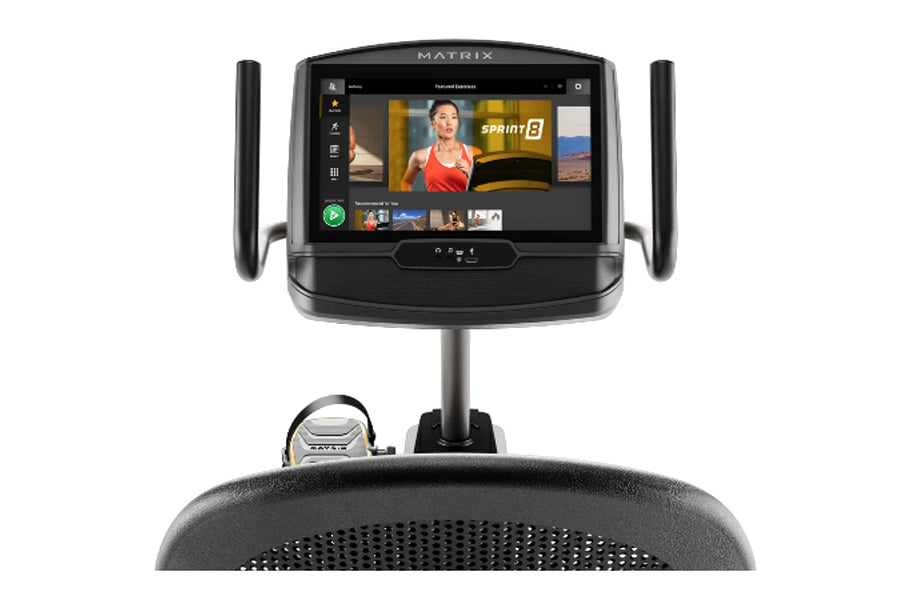 Matrix R50 recumbent exercise bike with black frame, touchscreen display showing fitness app, and dual side handles on white 