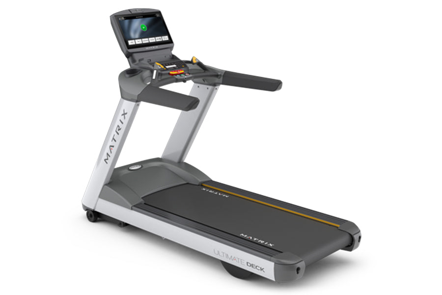 Matrix T130 motorized treadmill with black running deck, silver frame, digital console display, and hand grips, isolated on w