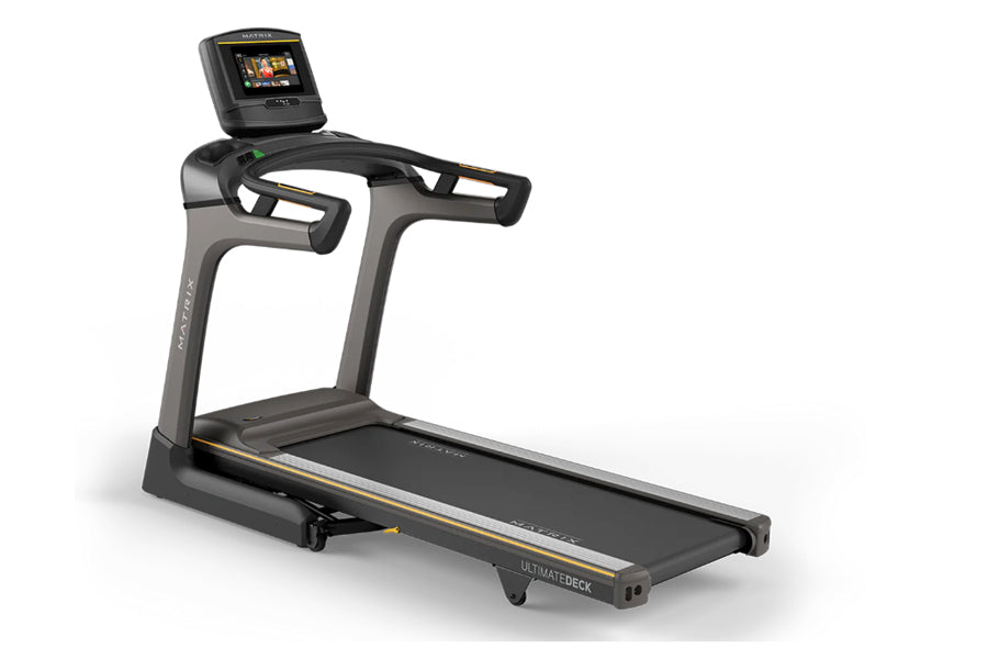 Matrix TF50 folding treadmill with gray frame, black running deck, gold accents, and digital display console on white backgro