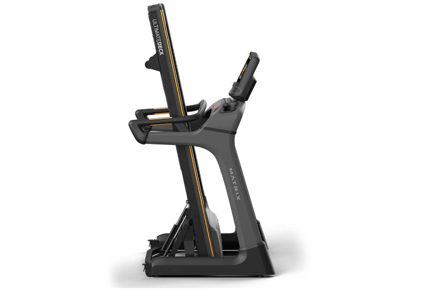 Matrix TF50 folding treadmill with black frame, gold accents, and digital console on white background