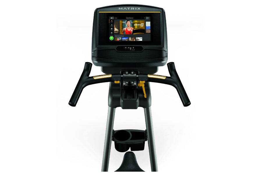 Matrix U30 upright exercise bike with black frame, gold accents, dual handles, and touchscreen display showing workout conten