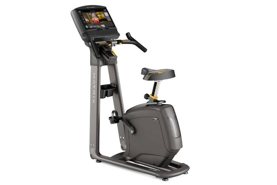 Black and gray Matrix U30 upright exercise bike with digital touchscreen display and padded seat on white background