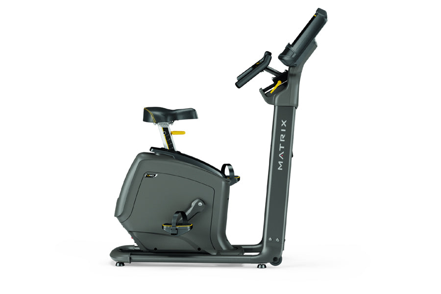 Matrix U50 upright exercise bike with black frame, padded seat, and digital display console on white background