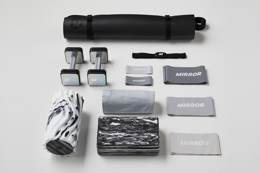 Lululemon Studio Mirror Pro home fitness equipment set including black cylindrical speaker, pair of small dumbbells, black he