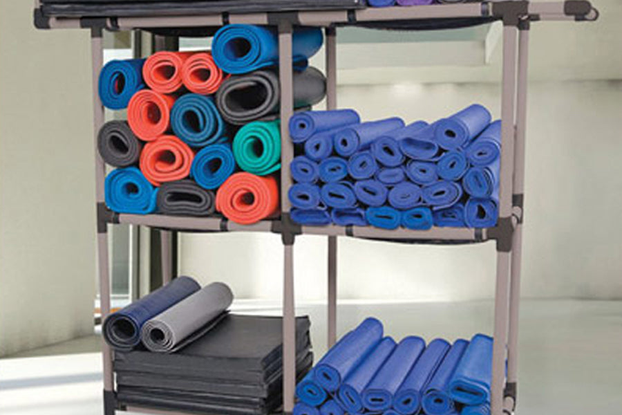 Metal storage rack displaying rolled yoga mats and foam rollers in blue, red, coral, gray, and black colors on four tiers