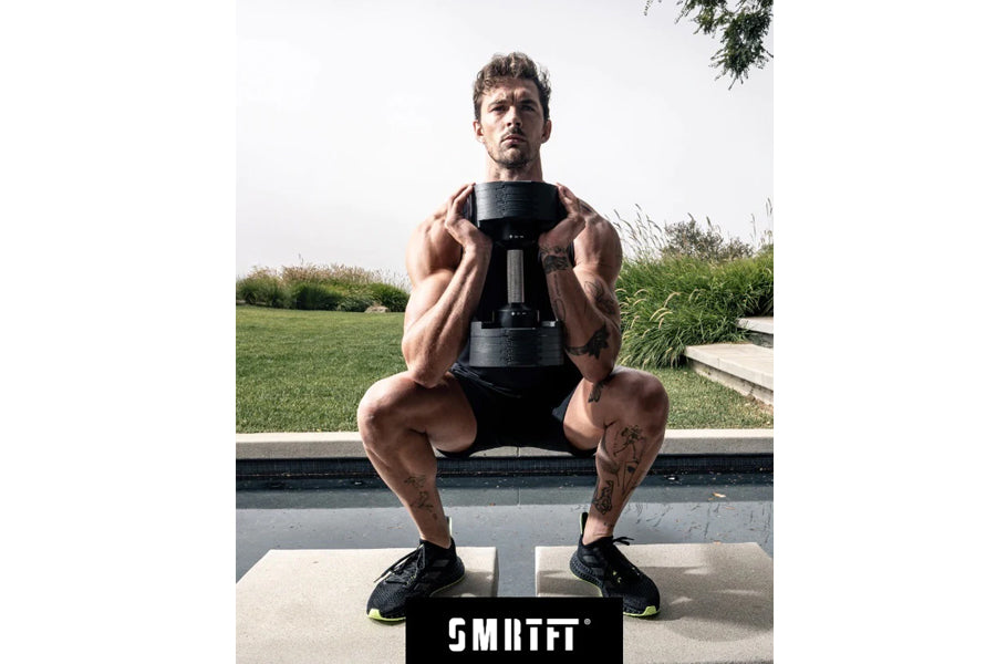 Man performing dumbbell squat with black adjustable 50lb dumbbell in outdoor setting