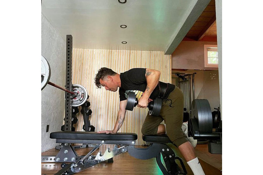 Man performing dumbbell curl with matte black adjustable weight in home gym setting
