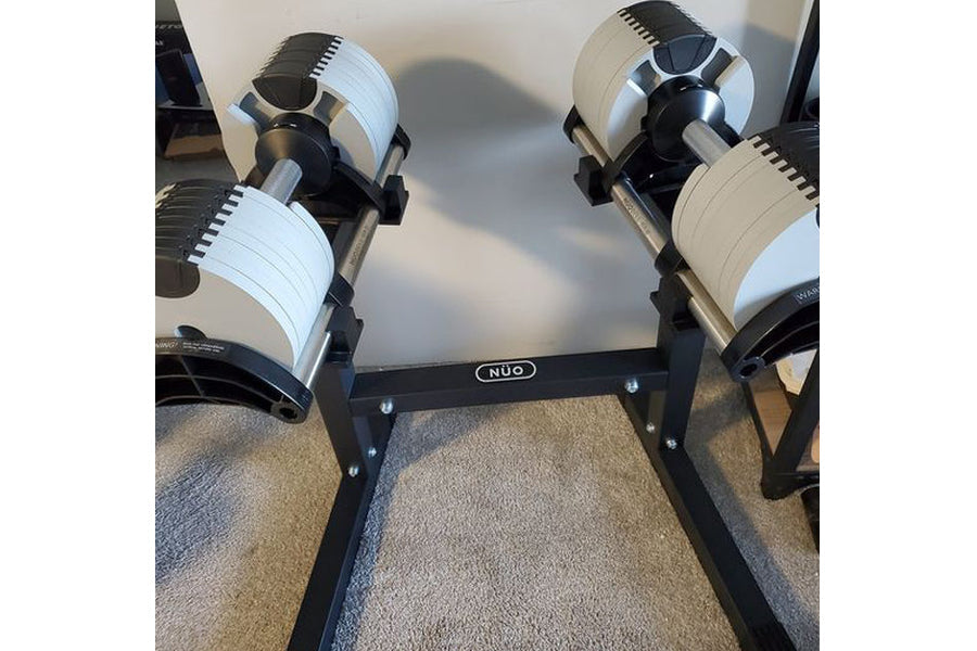 NÜOBELL 80lb adjustable dumbbells with white and black design on black stand, flat lay view