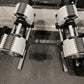 NÜOBELL 80lb adjustable dumbbells with white and gray plates, chrome handles, on black base, overhead view