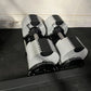 Pair of white and black adjustable dumbbells with metal handles on black weight stand