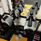 NÜOBELL adjustable dumbbells in ash gray and black, displayed in set of five with weight plates on black rack base