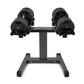 Pair of black NÜOBELL adjustable dumbbells on gray stand, flat lay on white background