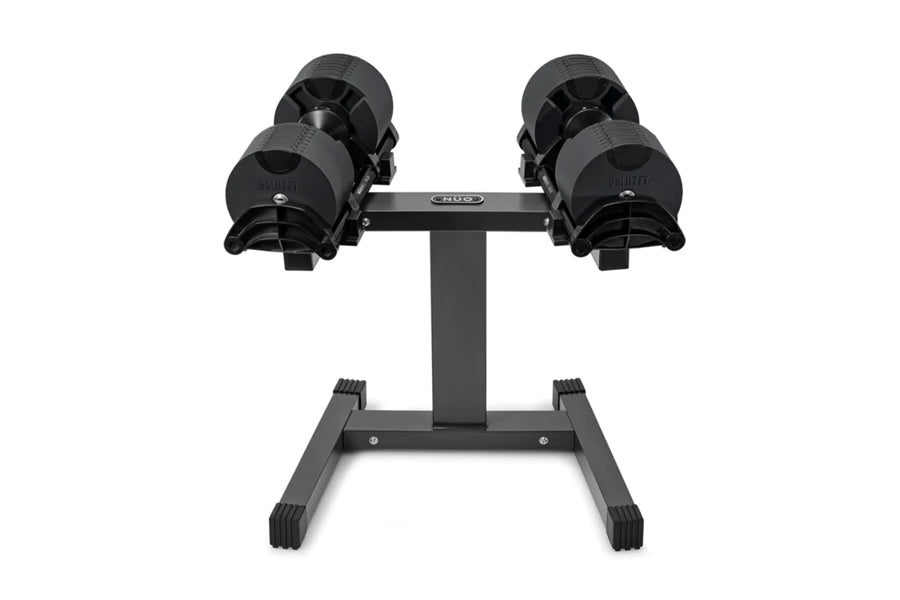 Pair of black NÜOBELL adjustable dumbbells on gray stand, flat lay on white background