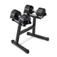 Pair of black adjustable dumbbells with metal handles on matching stand, isolated on white background