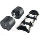 Pair of black adjustable dumbbells with chrome handles and matching black stand, flat lay on white background