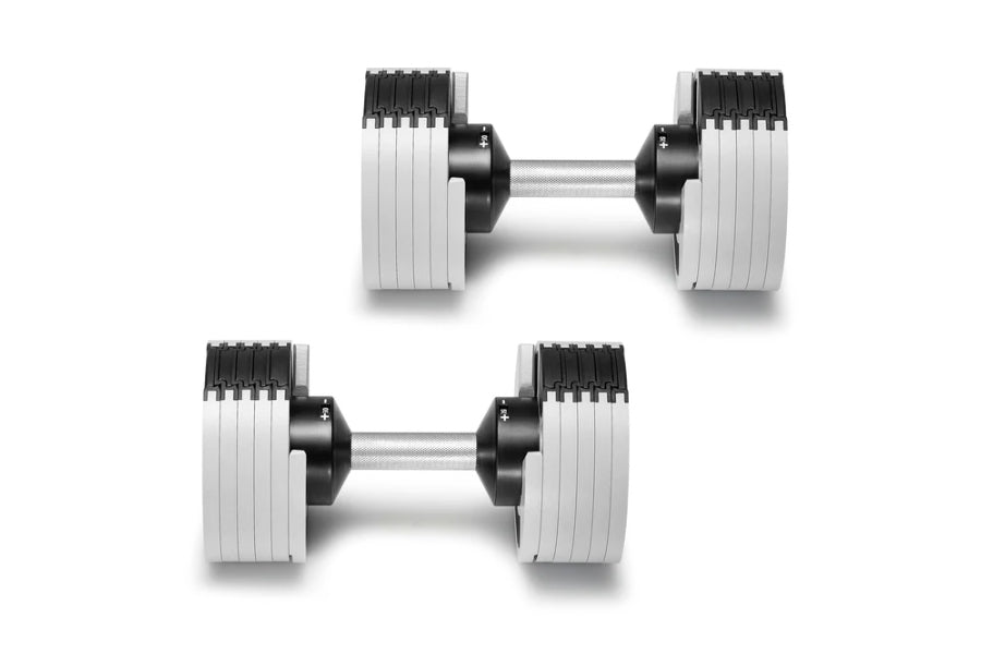 Pair of NÜOBELL adjustable dumbbells with white rectangular weight plates and black handles on white background