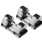 Pair of NÜOBELL adjustable dumbbells with white weight plates, black caps, and metal handles on black bases, shown on white b