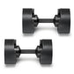 Pair of matte black adjustable dumbbells with ridged weight plates and dark gray handles, shown on white background