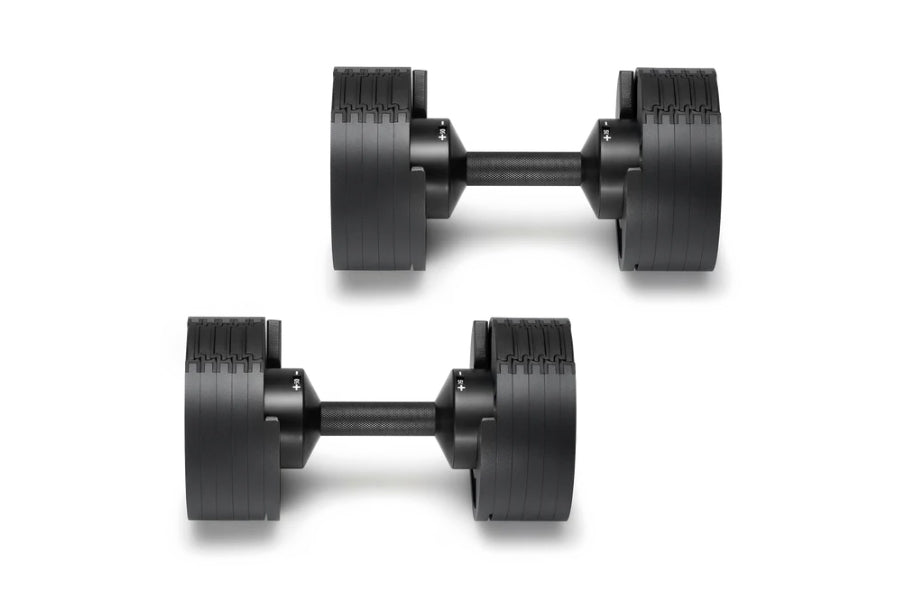 Pair of matte black adjustable dumbbells with ridged weight plates and dark gray handles, shown on white background