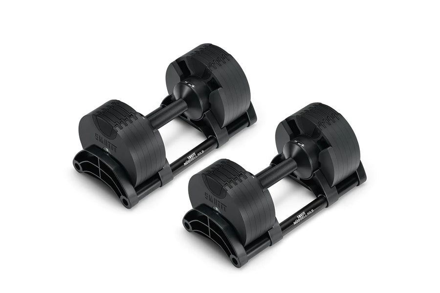 Pair of matte black adjustable dumbbells with rotating weight plates and black bases, on white background